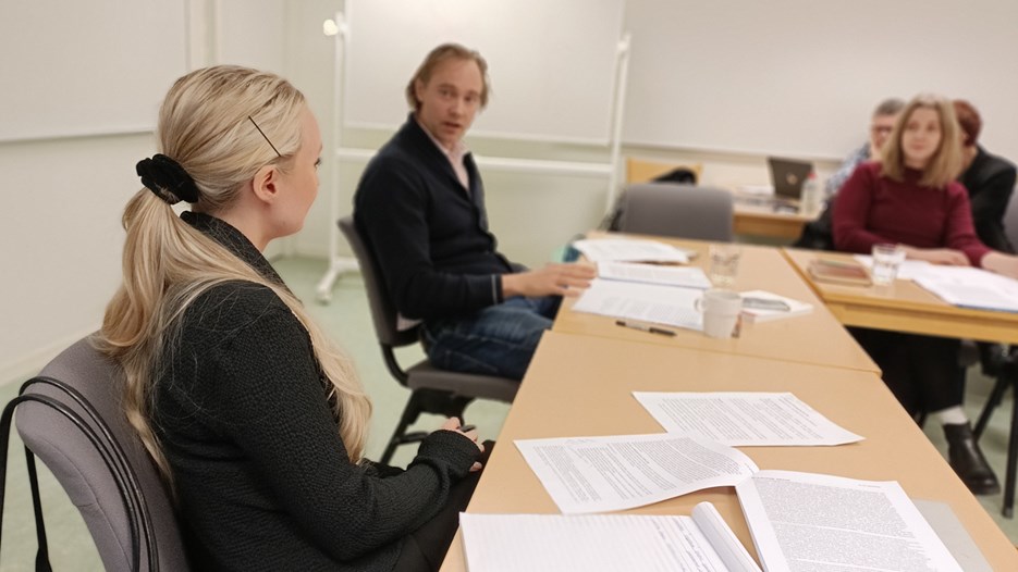 Madelen Johansson and David Sjögren sit by a table and discuss.