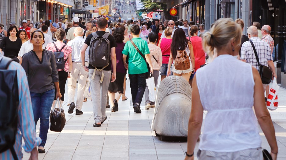 Sommardag på gågatan Drottninggatan mellan Mäster Samuelsgatan och Kungsgatan i Stockholm, Sverige, med folk i rörelse.