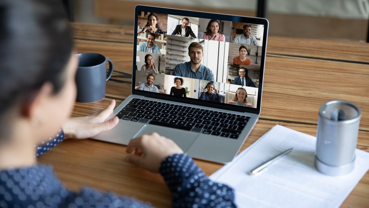 Person deltar i ett digitalt möte via skärmen på sin laptop.