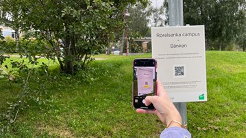 En station i programmet rörelserika campus, mobil skannar QR-kod på skylt.