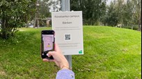 En station i programmet rörelserika campus, mobil skannar QR-kod på skylt.