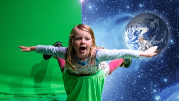 A girl flying in front of a green screen at Curiosum.
