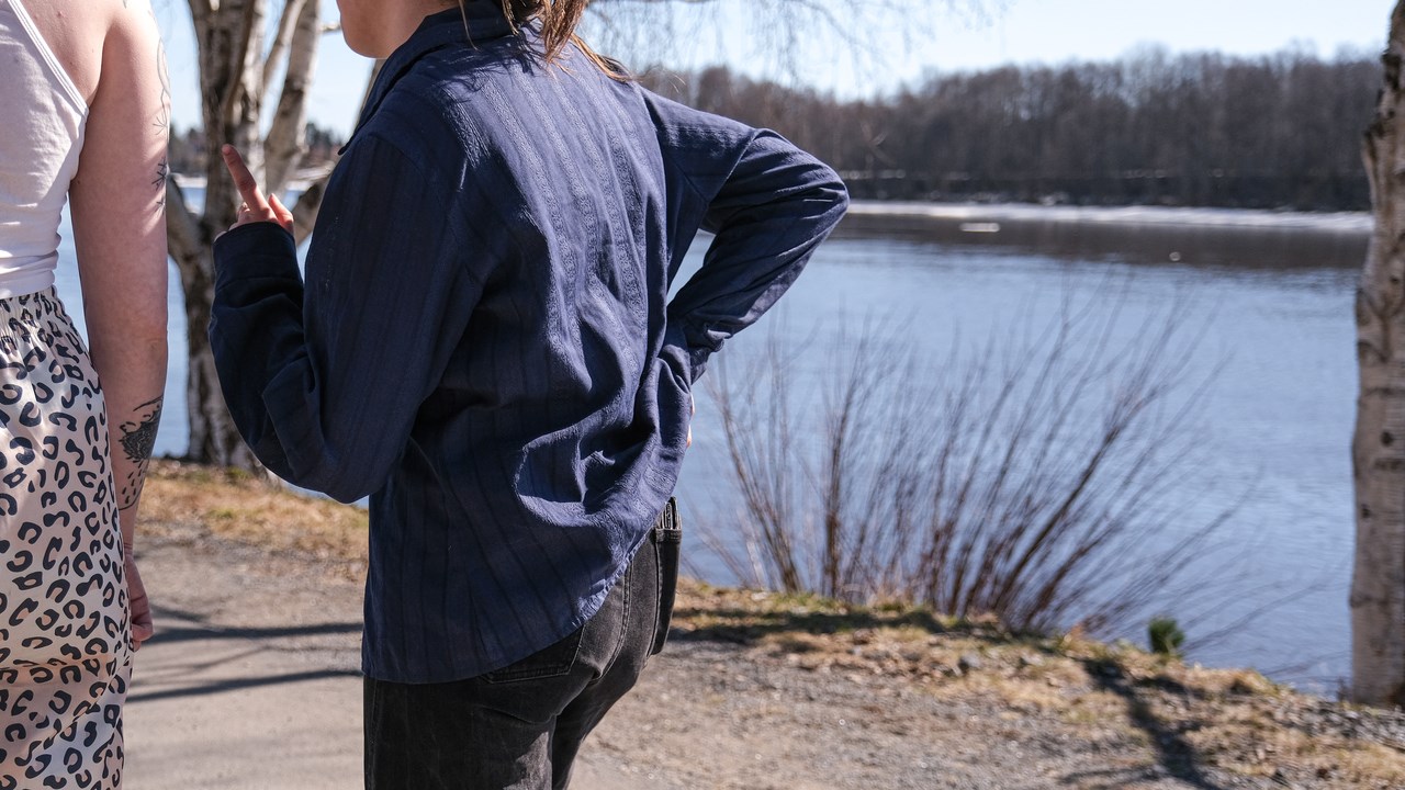 Två personer promenerar längst älven