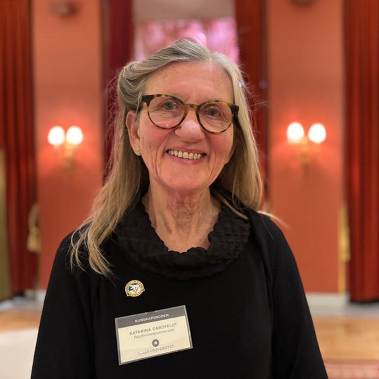 En kvinna med glasögon och svart skjorta.