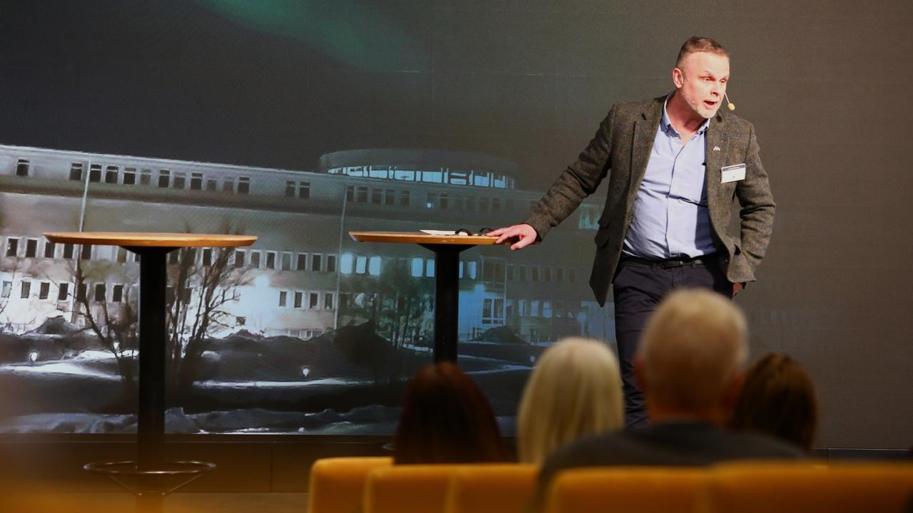 En man som står på ett podium framför en folkmassa.