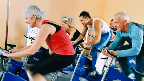 Personer på träningscykel i gym