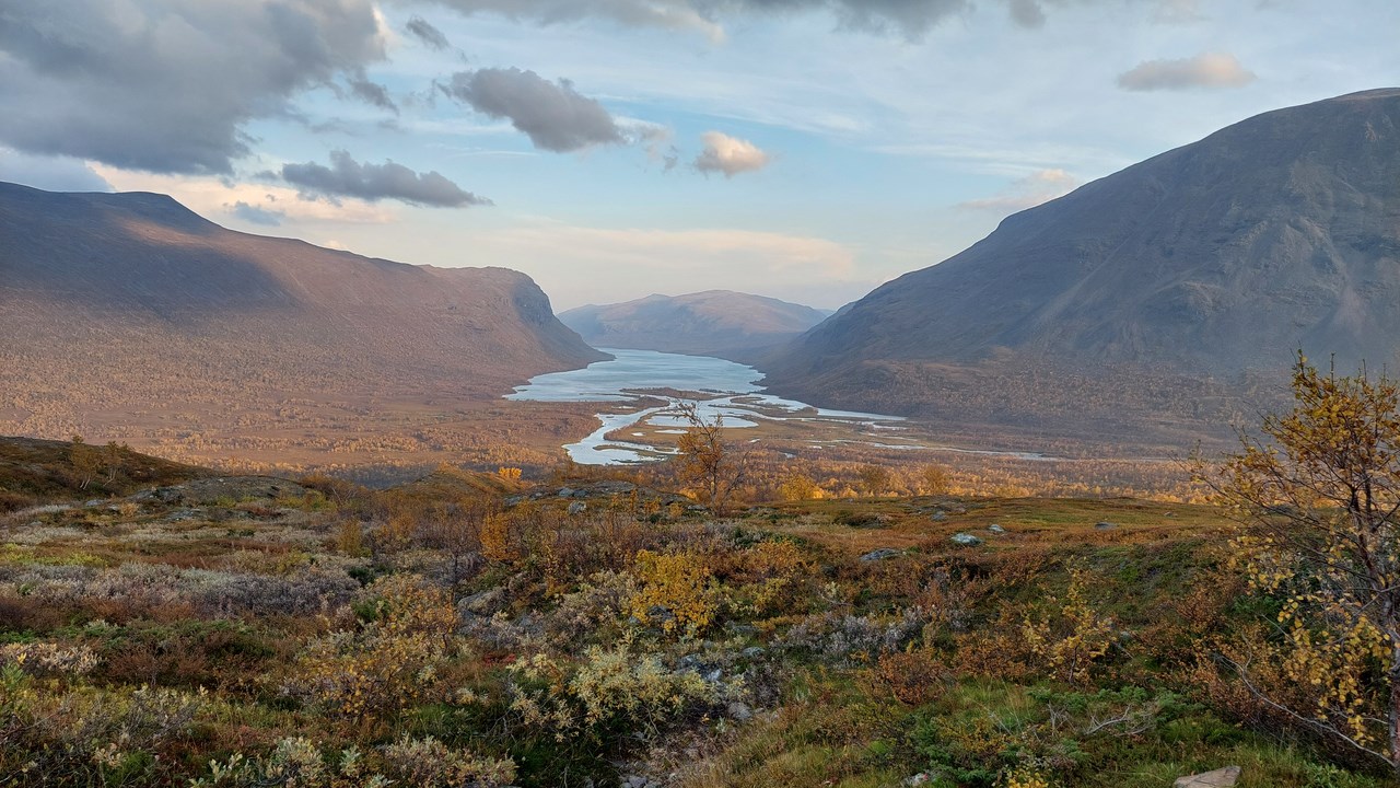 Vy över vattendrag genom fjällandskap.