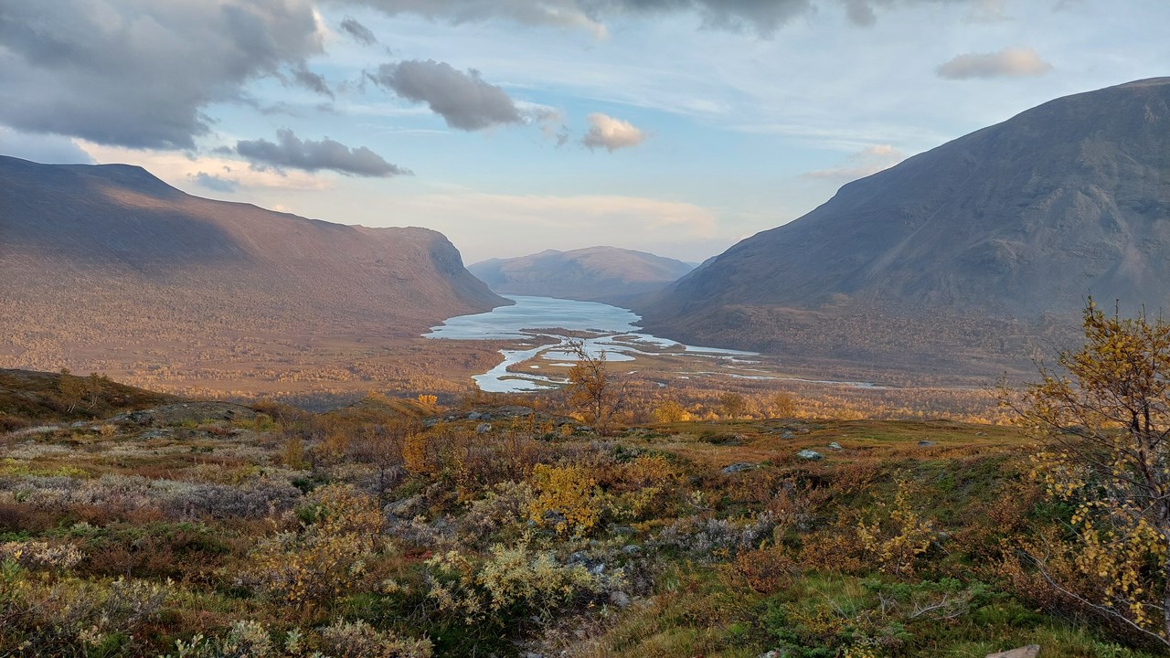 Vy över vattendrag genom fjällandskap.