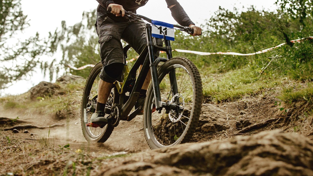 Person som åker mountain bike på en stig på ett berg.est