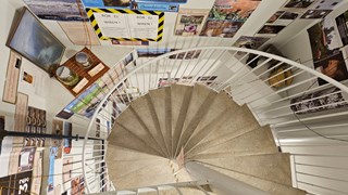 A spiral staircase with images on the walls.