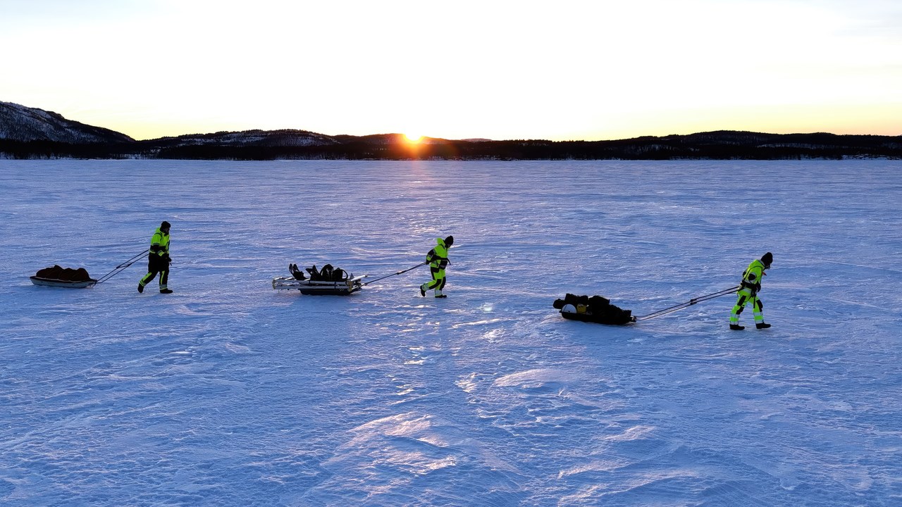 Three researchers walking over a frozen fjord in the documentary Fjords Frontiers: Digging into the future of climate change.