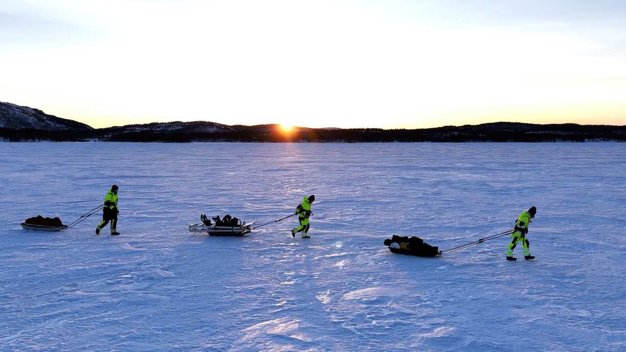 Three researchers walking over a frozen fjord in the documentary Fjords Frontiers: Digging into the future of climate change.