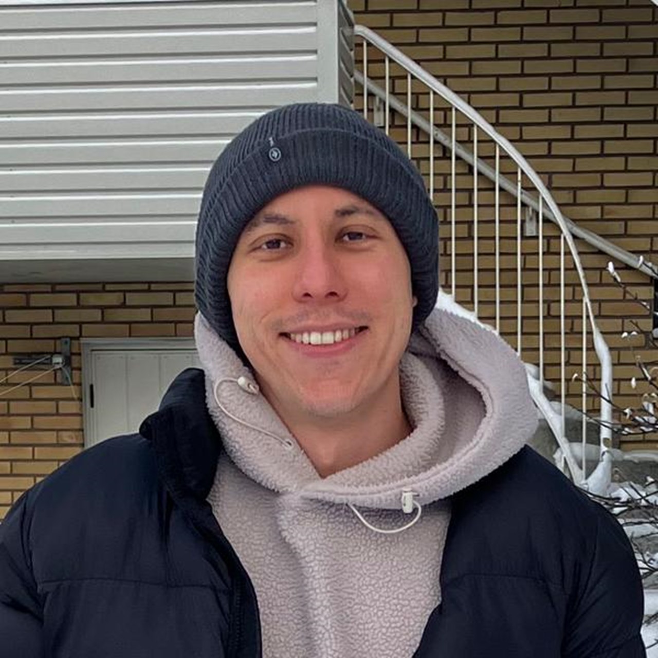 A man standing in the snow holding a shovel.