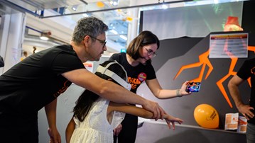 A man and a woman guide a child in a white dress with a white VR headset on