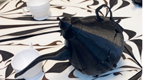 A black teapot sitting on top of a table