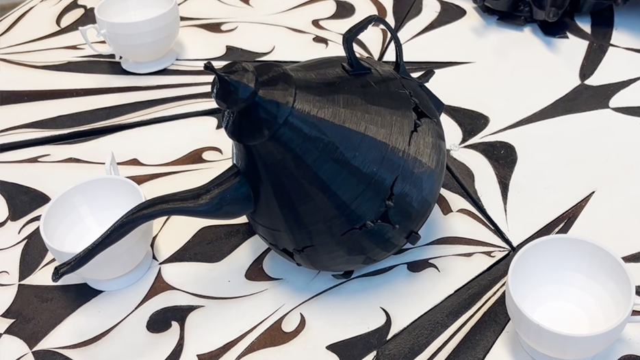 A black teapot sitting on top of a table