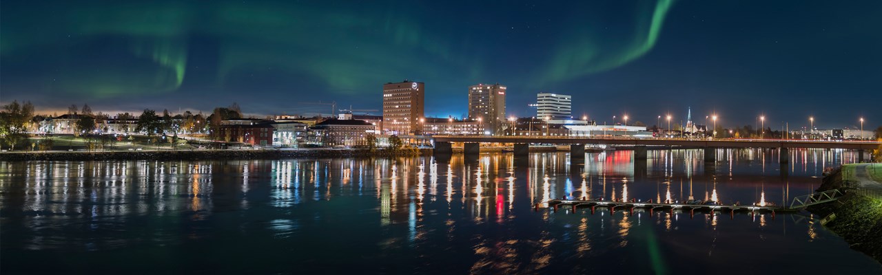 Umeå skyline med umeälven i förgrunden. Norrsken på himlen.