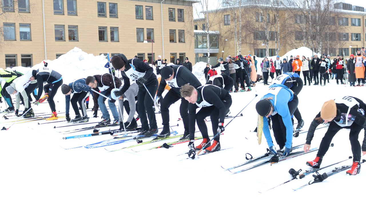 Participants of the skiing relay putting on their skis during the running start