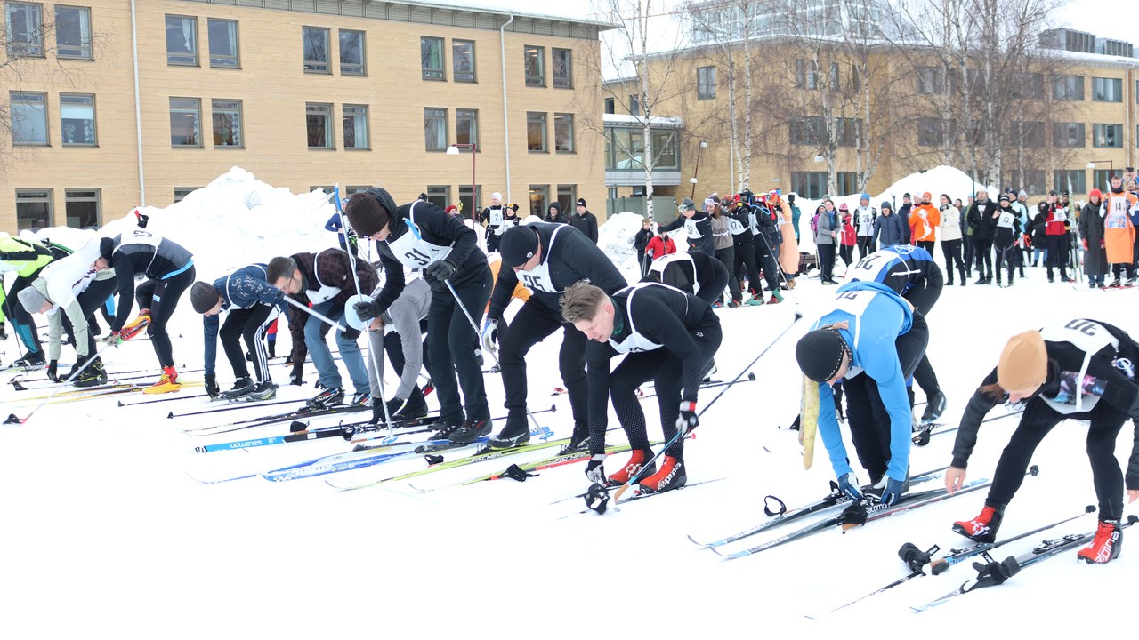 Participants of the skiing relay putting on their skis during the running start