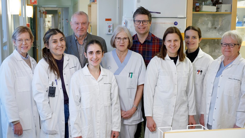 Group image in the biochemistry lab featuring Helena Alstermark, Ani Minasian, Stefan Marklund, Laura Leykam, Karin Hjertkvist, Per Zetterström, Eva Jonsson, Caitlin Henne and Agneta Öberg. All are smiling and all, except the group leaders, are wearing lab attire.