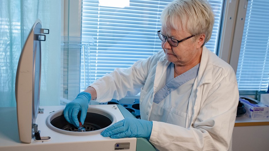 Agneta Öberg is placing a microcentrifuge tube in a benchtop centrifuge.