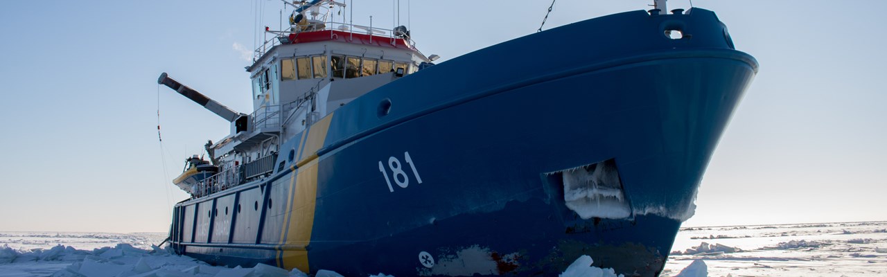 Ett stort blått fartyg märkt 181 stävar fram genom tjock is