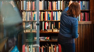 Kvinna söker efter böcker i bibliotek