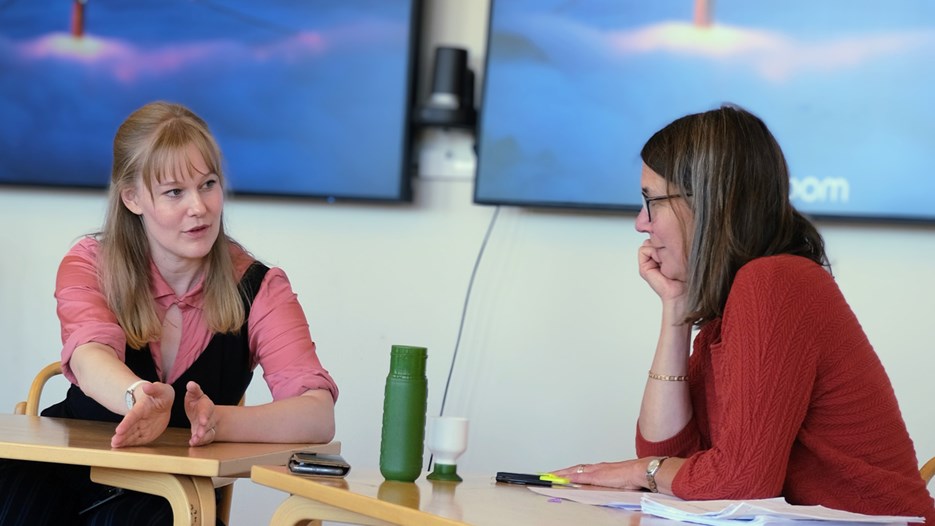 Amanda och Evelien sitter vid ett bord och pratar med varandra