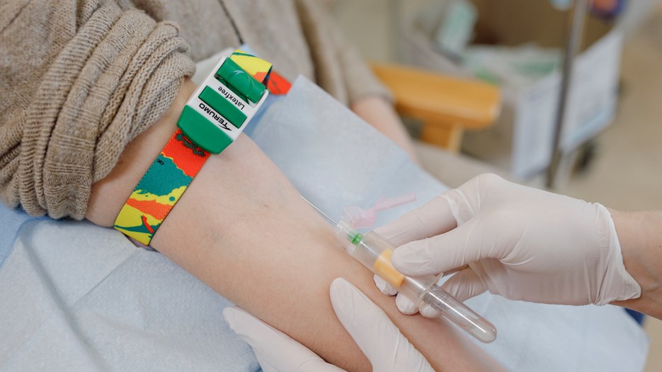 Close-up of an arm fold where a blood sample is about to be taken with the use of a needle attached to a vacutainer blood collection tube.