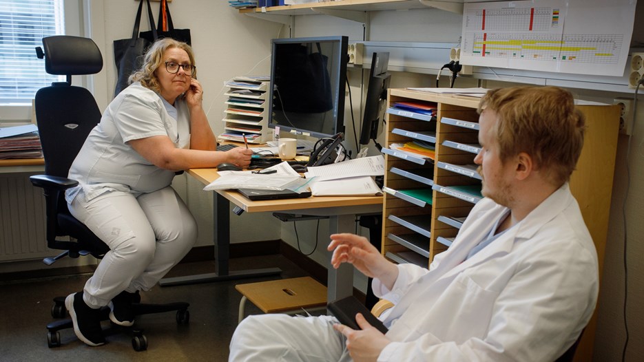 Nina Sundqvist is sitting in her chair taking notes. She is looking at Ivar Winroth, who is sittting in a visitors’ chair, talking to her.