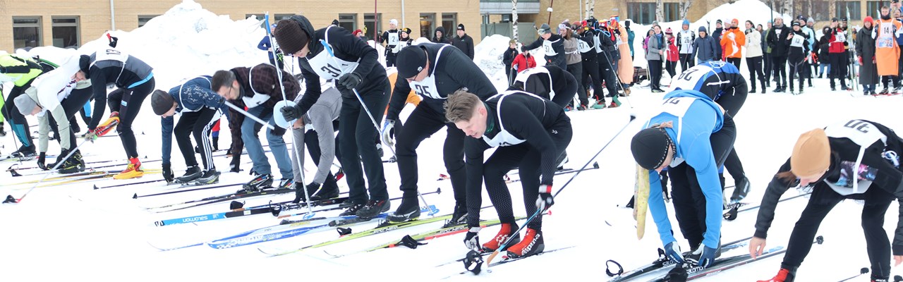 Participants of the skiing relay putting on their skis during the running start