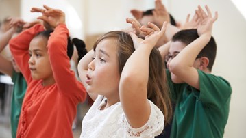 En grupp barn som dansar bredvid varandra.