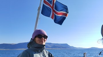 Utbytesstudent på en båt som viftar med en flagga av Island