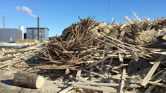 Wood debris at the ground, and a factory in the background.