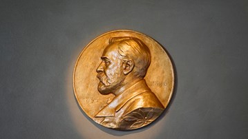 Närbild på guldmedaljen som delas ut i Nobelpriset med Alfred Nobels ansikte ingraverat.