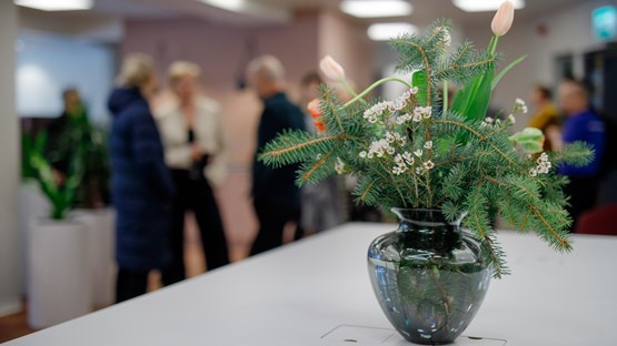 Close-up on a flower pot, and blurred people in the background.