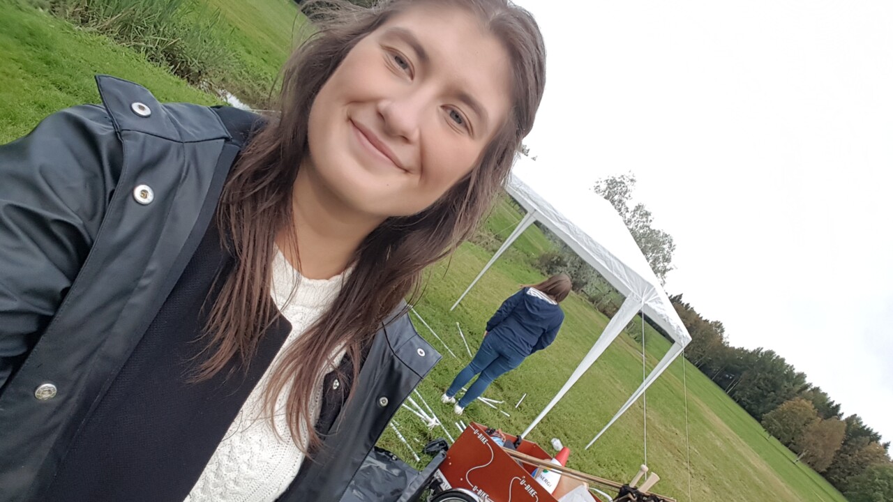 Photo of Buddy Coordinator Helin Bäckman Kartal in front of a U-bike and a tent