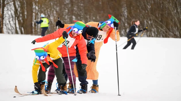 A group of people in colorful clothes on skis in the snow