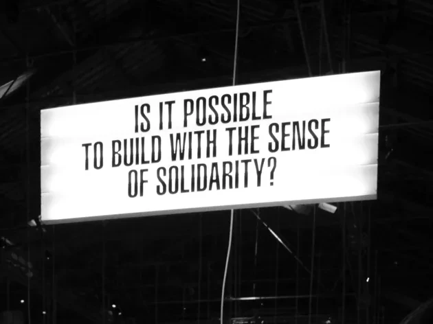 sign with text "is it possible to build with the sense of solidarity?"