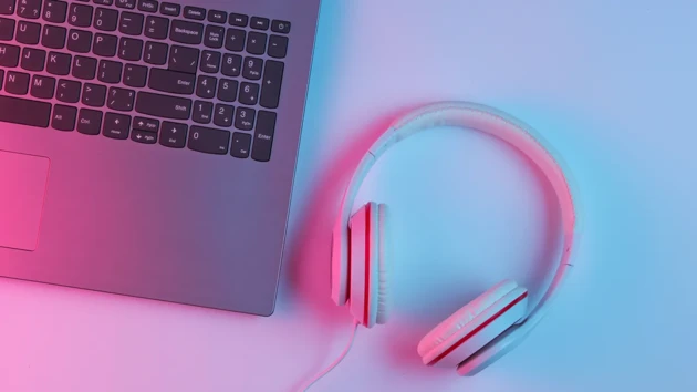 A pair of headphones next to a computer.