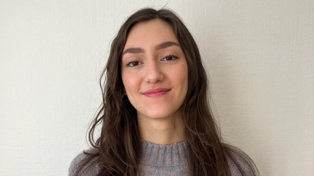 Emma Biondani, arkitektstudent, stående i halvfigur med vit vägg i bakgrunden