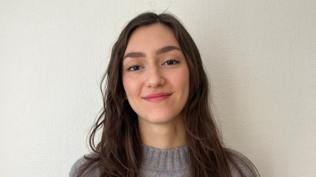 Emma Biondani, arkitektstudent, stående i halvfigur med vit vägg i bakgrunden