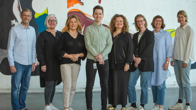 Eight staff members from the Student Health Service in a row indoors.