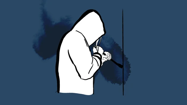 A hooded person is trying to break in using a crowbar.