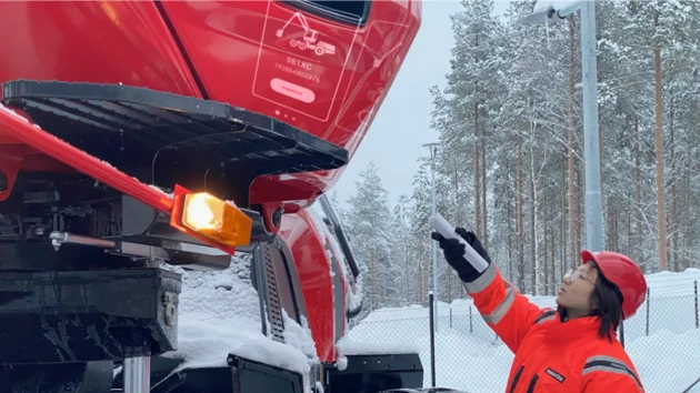 A mechanic uses the MaxiFlare to project the reporting interface on the machine.