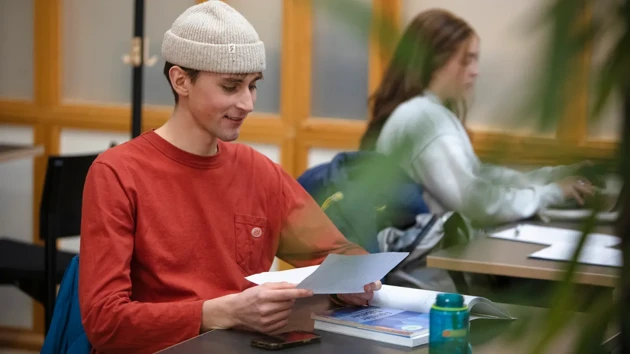 A student sat at a table looking at a paper. 