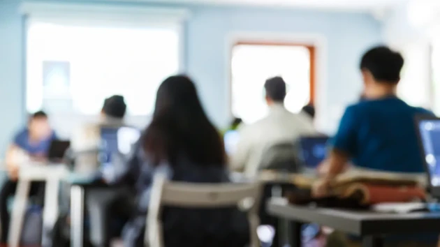 Utsuddade personer i en lektionssal som är med på en föreläsning eller seminarium.