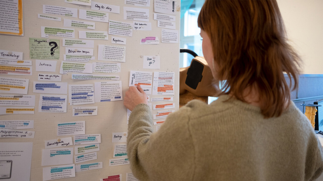 Person står framför anslagstavla under en workshop