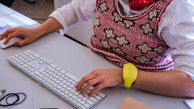 Foto på person som sitter vid ett skrivbord med en prototyp på handleden